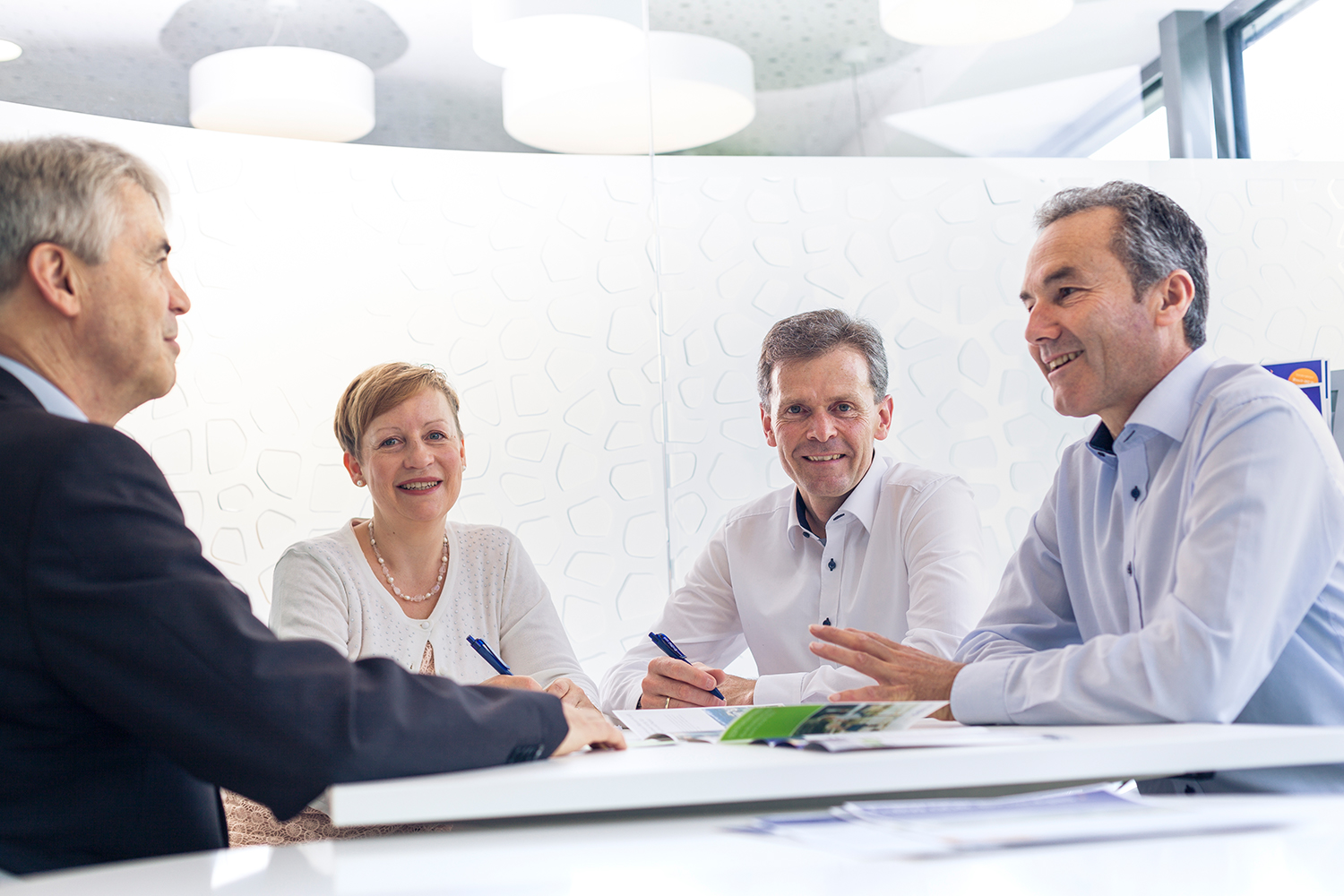 Drei Männer und eine Frau bei einem Meeting 