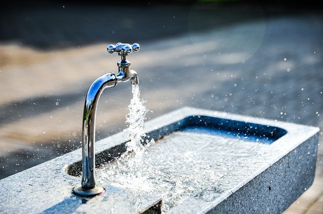 Wasser spritz aus Wasserhahn bei einem Brunnen 