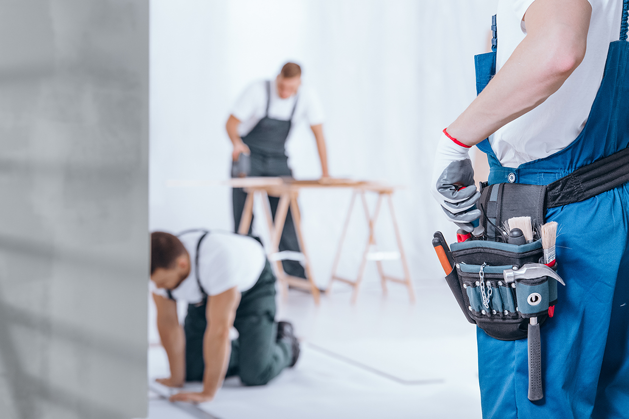 Drei Handwerker renovieren in einem Haus 