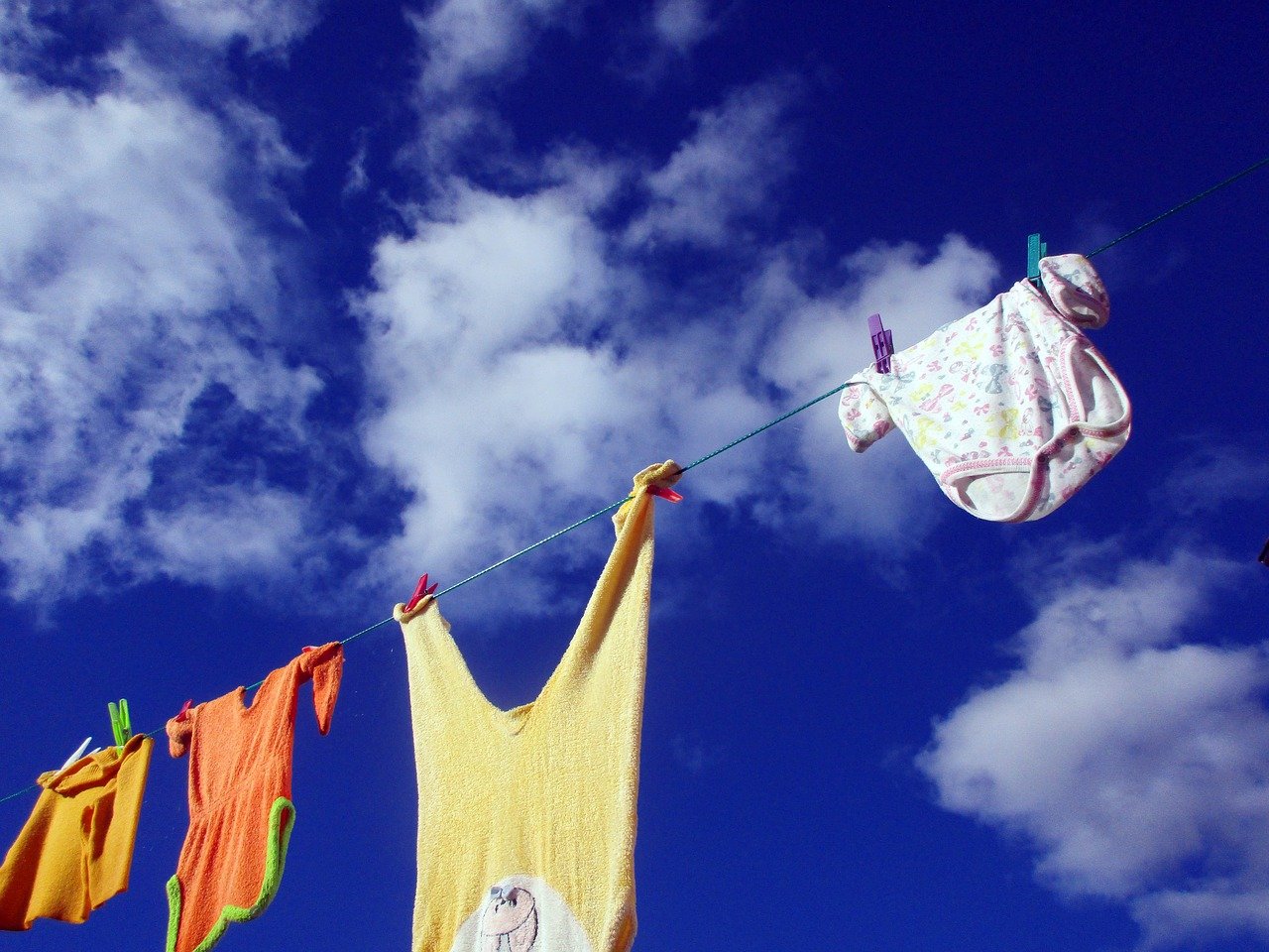 Wäsche trocknet an Wäscheleine unter blauem Himmel