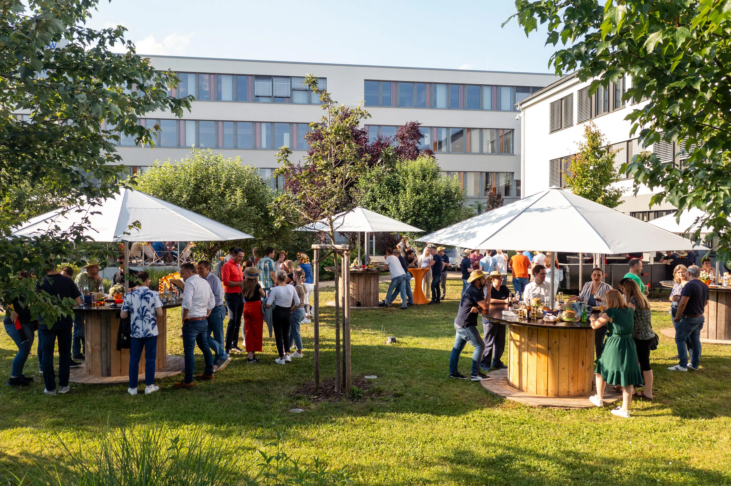 Mitarbeitende im Firmengarten der ODR an Stehtischen